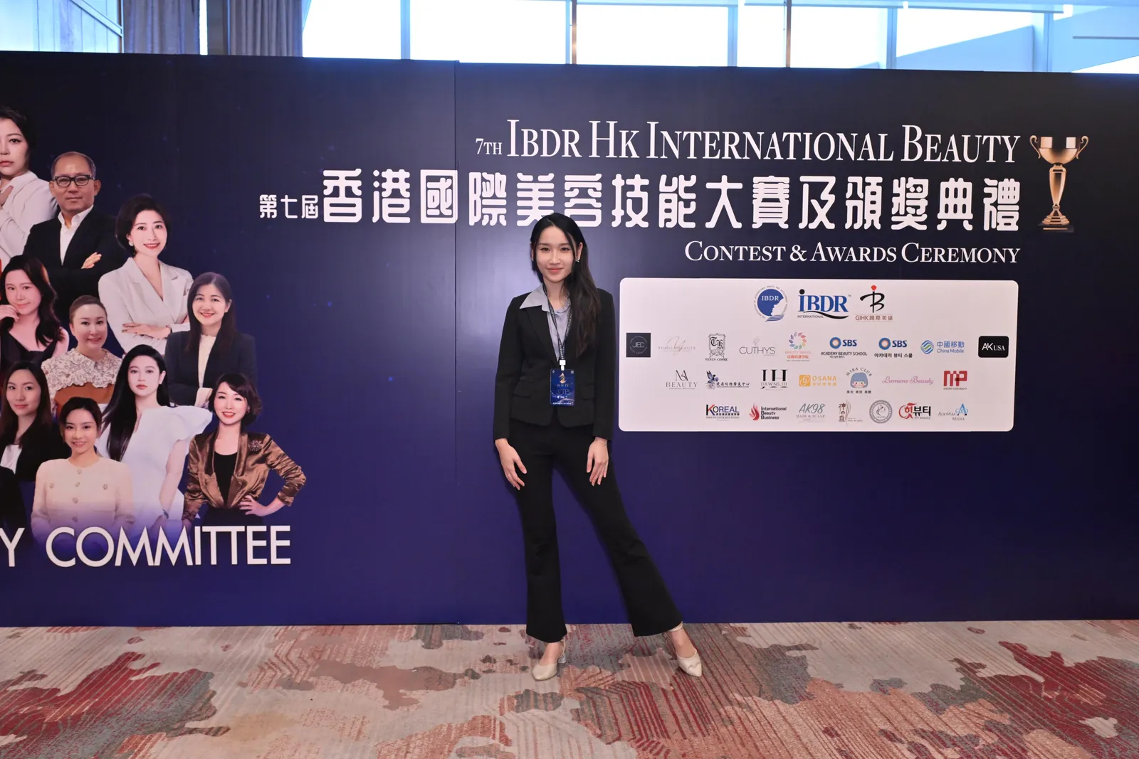 Iris in front of the IBDR Hong Kong International Beauty Skills Competition 2025 judging panel backdrop