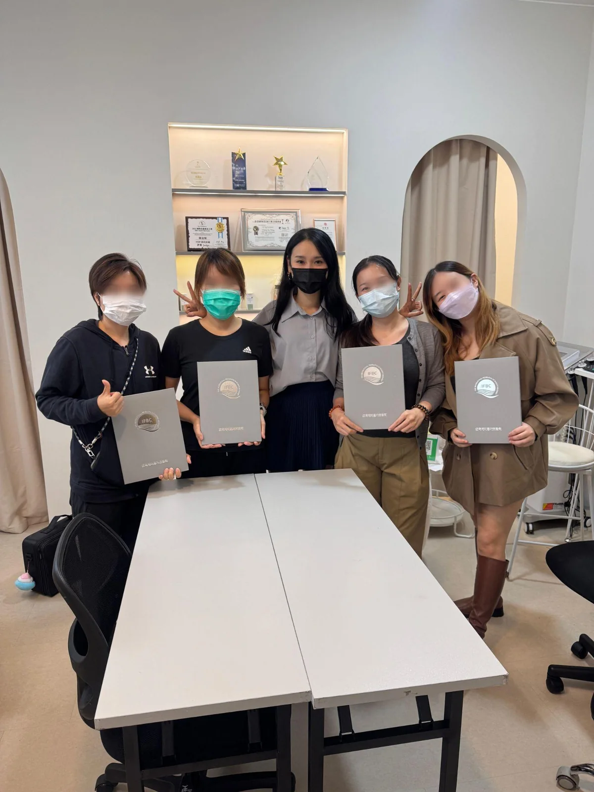 Graduates holding their certificates in the studio
